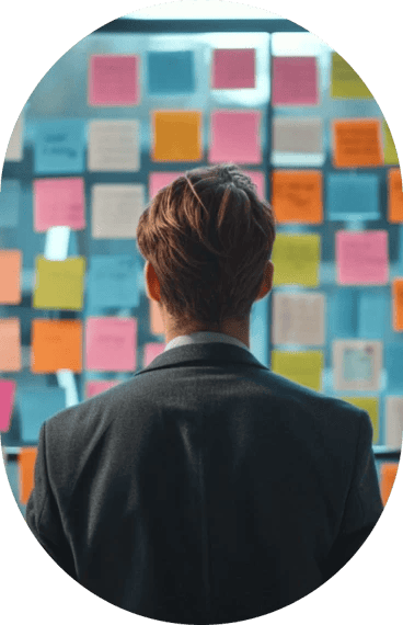 Person contemplating a wall of sticky notes